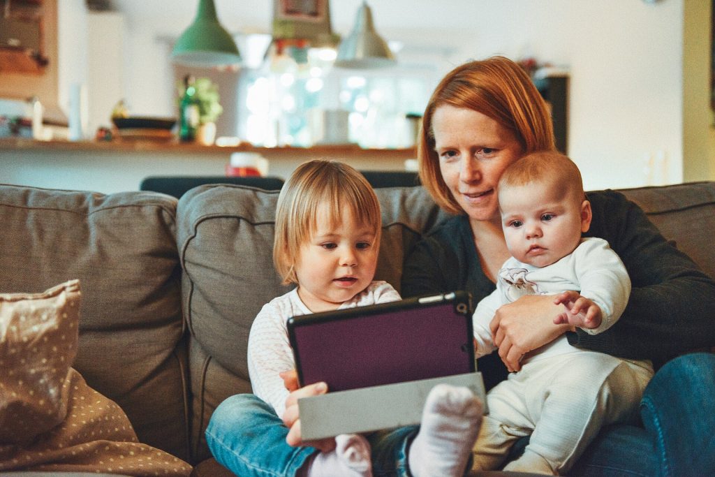 Una madre con sus dos hijos en el sofá de casa