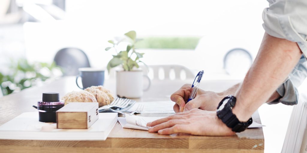 Una persona rellenando un formulario sobre una mesa